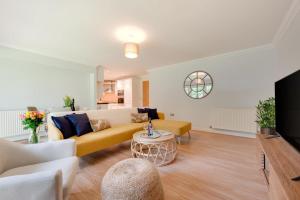 a living room with a yellow couch and a tv at 2 Bed in Carlyon Bay oc-crinni in Carlyon Bay