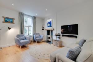 a living room with a couch and chairs and a tv at 2 Bed in Fowey oc-forty in Fowey