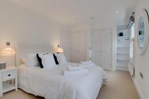 a white bedroom with a white bed with towels on it at 2 Bed in Fowey oc-forty in Fowey