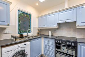 a kitchen with white cabinets and a dishwasher at 2 Bed in Seahouses oc-nb1974 in North Sunderland +4 photos