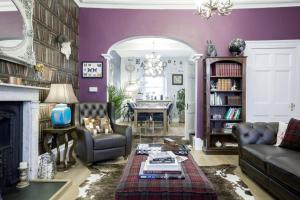 a living room with purple walls and a fireplace at The Town House at Brecon in Brecon