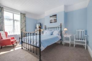 a bedroom with blue walls and a bed and a chair at 5 Bed in Runswick oc-wa326 in Runswick