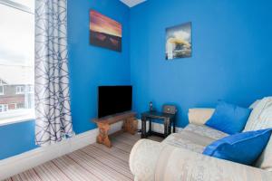 a blue living room with a couch and a tv at 5 Bed in Runswick oc-wa326 in Runswick