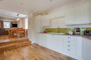 a kitchen with white cabinets and a dining room at 4 Bed in Gayle oc-ds950 in Hawes