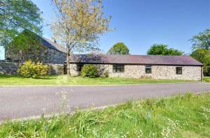 an old stone barn with a road in front of it at 2 Bed in Menai Bridge oc-fl046 in Llandegfan