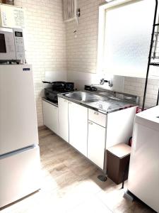 a white kitchen with a sink and a refrigerator at シーシャイン北金沢 102号室 in Aomori +9 photos