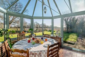 a conservatory with a table with food on it at 6 Bed in Wymondham oc-t30598 in Wymondham