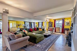 a large living room with a green couch and chairs at 6 Bed in Wymondham oc-t30598 in Wymondham