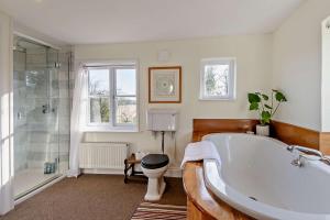 a bathroom with a tub and a toilet and a shower at 6 Bed in Wymondham oc-t30598 in Wymondham +22 photos
