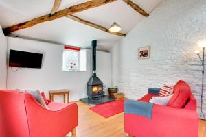 a living room with two red chairs and a fireplace at 1 Bed in Totnes oc-bcbove in Broadhempston