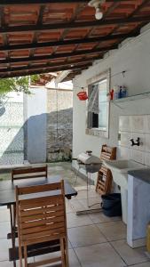 a patio with a table and chairs and a sink at Casa Rústica no centro de Araruama in Araruama