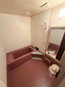 a bathroom with a red tub and a sink at ホテルプチハウス大人専用 in Barajima