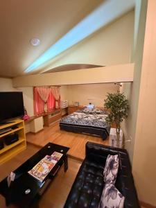 a living room with a bed and a couch at ホテルプチハウス大人専用 in Barajima