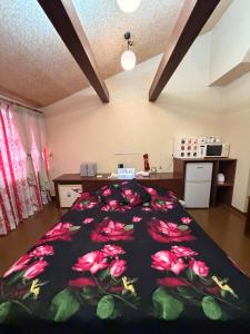 a bedroom with a bed with red flowers on it at ホテルプチハウス大人専用 in Barajima +15 photos