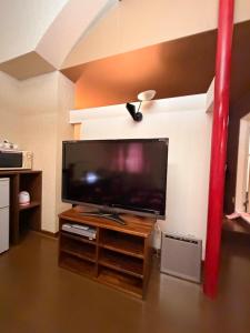 a flat screen tv sitting on a stand in a room at ホテルプチハウス大人専用 in Barajima
