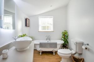 a bathroom with a tub and a toilet and a sink at 1 Bed in Tasburgh oc-t28242 in Ashwellthorpe +14 photos