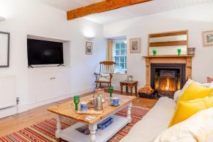 a living room with a table and a fireplace at 5 Bed in Little Petherick oc-melynw in Little Petherick