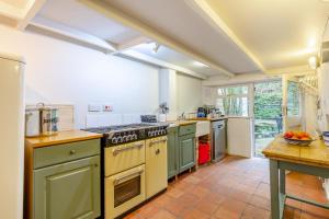 a kitchen with green cabinets and a stove top oven at 5 Bed in Little Petherick oc-melynw in Little Petherick