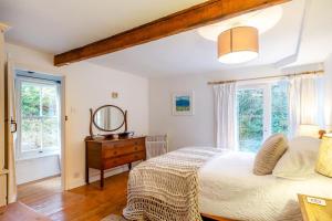 a bedroom with a bed and a dresser and windows at 5 Bed in Little Petherick oc-melynw in Little Petherick