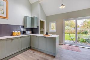 a kitchen with green cabinets and a large window at 3 Bed in Loweswater oc-w30224 in Loweswater