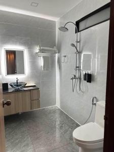 a bathroom with a shower and a toilet and a sink at Oasis VangVieng Resort & Cafe in Ban Naka