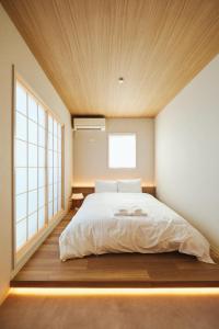 a bedroom with a large bed with a wooden ceiling at 若葉ホテル in Tokyo