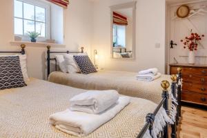 a bedroom with two beds and a dresser and a mirror at 3 Bed in Chale oc-s30298 in Chale +20 photos