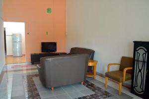 a living room with a couch and chairs and a television at Homestay Kota Bharu, Telipot in Kota Bharu