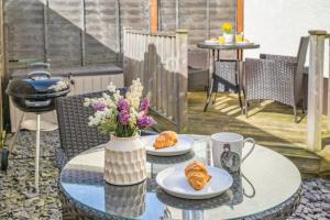 a table with two plates of croissants and a vase of flowers at 2 Bed in Trecastle oc-c30837 in Trecastle