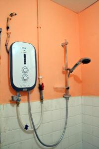 y baño con ducha y dispensador de jabón. en Homestay Kota Bharu, Telipot en Kota Bharu