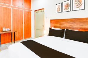 a bedroom with a white bed and a wooden headboard at Super Collection O SS BLUE INN in Hyderabad