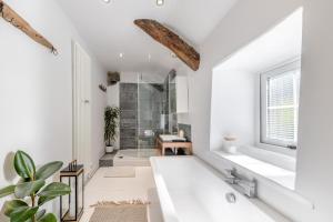 a bathroom with a white tub and a shower at 1 Bed in Harlech oc-t32043 in Harlech +26 photos