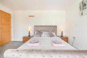 a white bedroom with a large bed with two pink towels at 3 Bed in Hythe oc-s32090 in Hythe