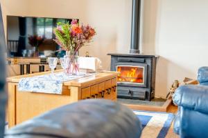 a living room with a fireplace and a vase of flowers at 3 Bed in Woodford oc-w32062 in Kilkhampton