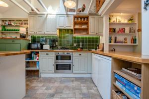 a kitchen with white cabinets and green tiles at 2 Bed in Wimborne oc-s30924 in Wimborne Minster