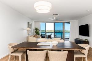 a dining room with a table and chairs and a living room at Riverside Apartments & Hotel in Ballina