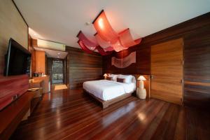 a bedroom with a bed and a flat screen tv at Baan Krai Nao The Riverfront in Bangkok