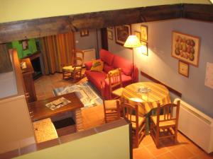 a living room with a red couch and a table at Apartamentos Saqura in Segura de la Sierra