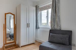 a living room with a mirror and a chair at 1 Bed in Seahouses oc-gd1735 in Seahouses