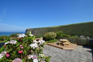 a patio with a table and some flowers at 2 Bed in Crackington Haven oc-p00596 in Crackington Haven