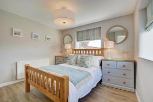 a bedroom with a bed and a dresser and mirror at 2 Bed in Crackington Haven oc-p00596 in Crackington Haven
