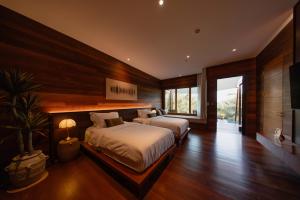 a bedroom with two beds and a large window at Baan Krai Nao The Riverfront in Bangkok