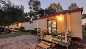 a tiny house with a porch and stairs in a yard at BIG4 Barham Holiday Park in Barham