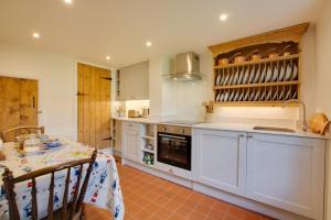 a kitchen with white cabinets and a table with a tablecloth at 2 Bed in Docking oc-913 in Docking