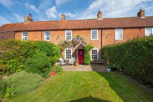 a brick house with a red door and a yard at 2 Bed in Docking oc-913 in Docking