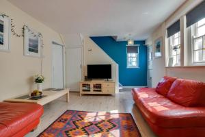 a living room with a red couch and a tv at 3 Bed in St. Ives oc-virg14 in St Ives