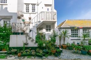 a white house with potted plants in front of it at 3 Bed in St. Ives oc-virg14 in St Ives
