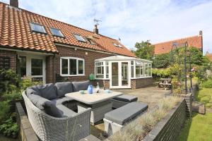 a patio with a couch and a table in a yard at 5 Bed in Walberswick oc-hferin in Walberswick