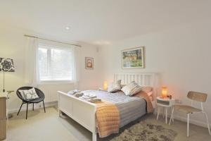 a bedroom with a bed and a chair and a window at 5 Bed in Walberswick oc-hferin in Walberswick