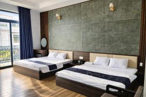 a hotel room with two beds and a large window at Valentin Motel 2 Đà Nẵng in Danang